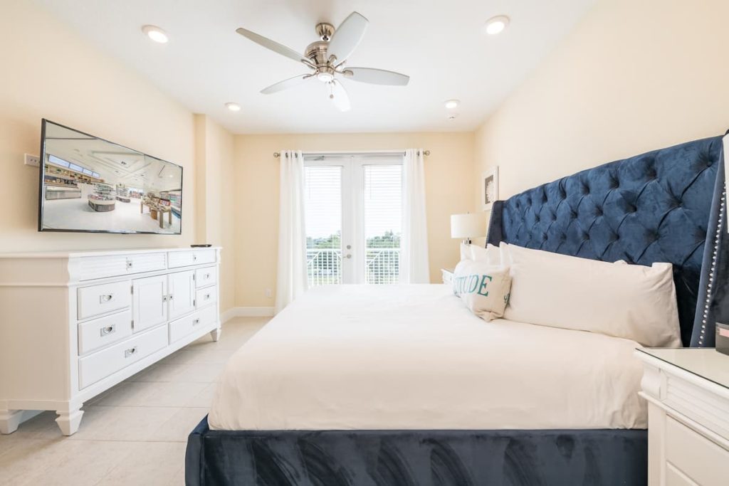 Seas Life Cottage at Margaritaville Resort Orlando guest king size bedroom with en suite bathroom and balcony.